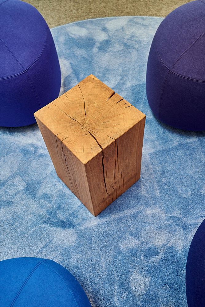 Detailaufnahme blaue COR Hocker und Holzblocktisch