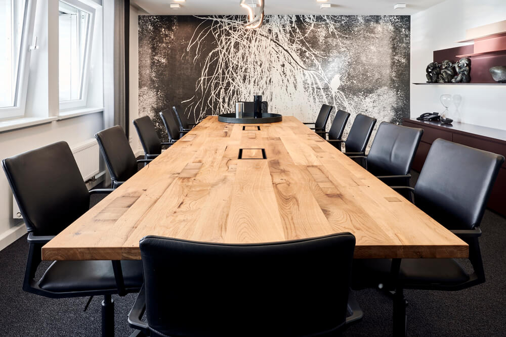 Holz-Konferenztisch mit schwarzen Lederstühlen